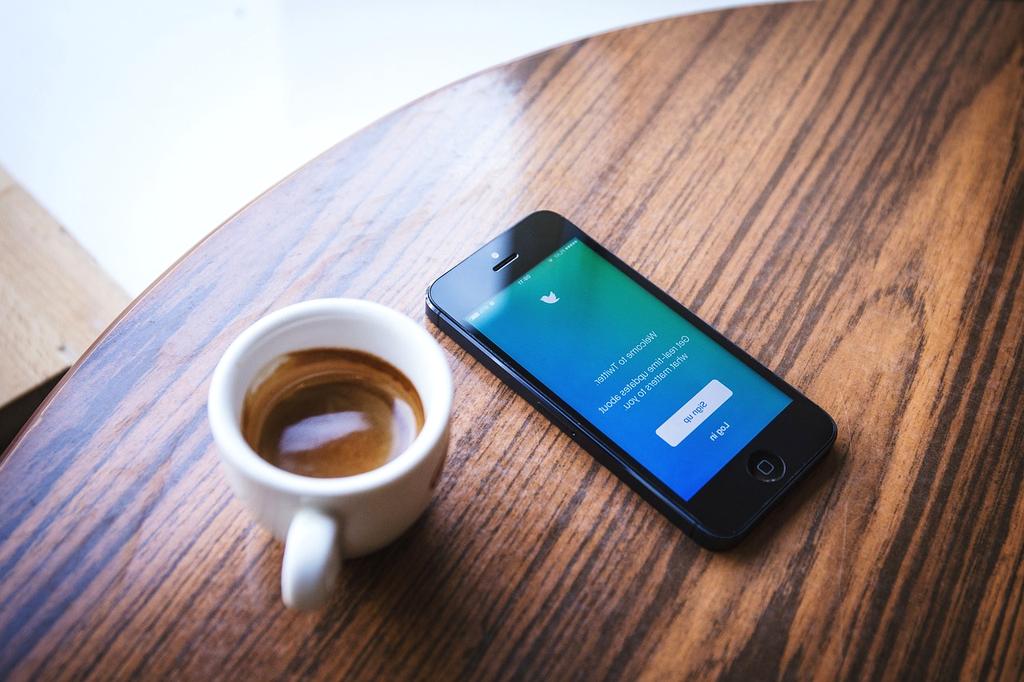 Social media icons floating above a smartphone